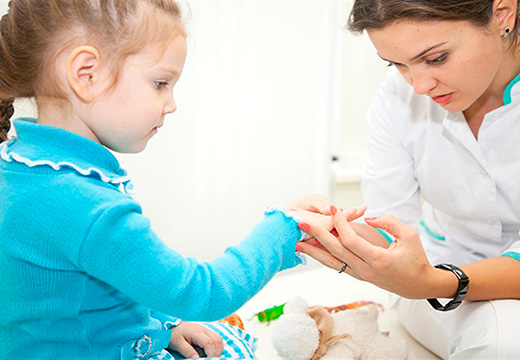 врач осматривает руку ребенка